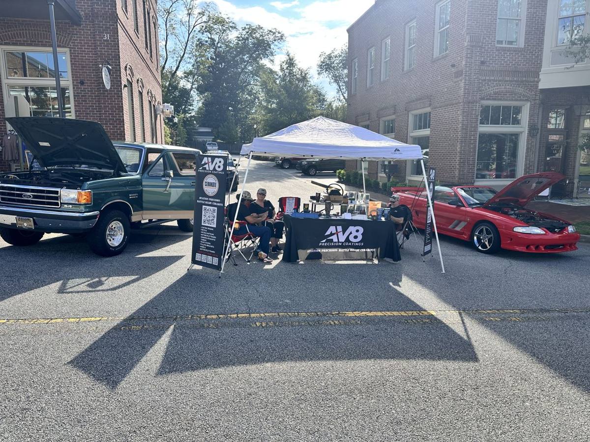 AV8 Precision Coatings tent at the Senoia Car Show with a 1990 Ford Bronco Eddie Bauer Edition and a 1994 Saleen Mustang
